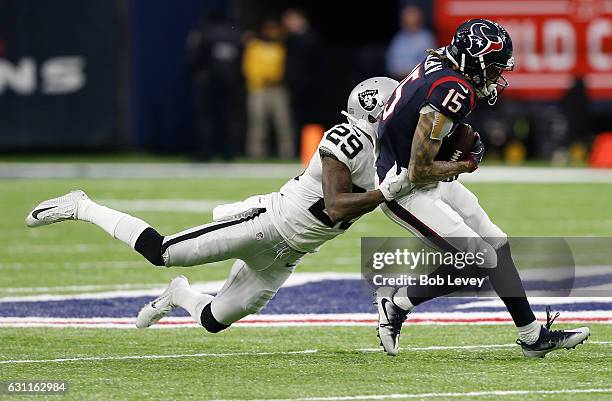Will Fuller of the Houston Texans is tackled by David Amerson of the Oakland Raiders after catching a pass during the second quarter of their AFC...