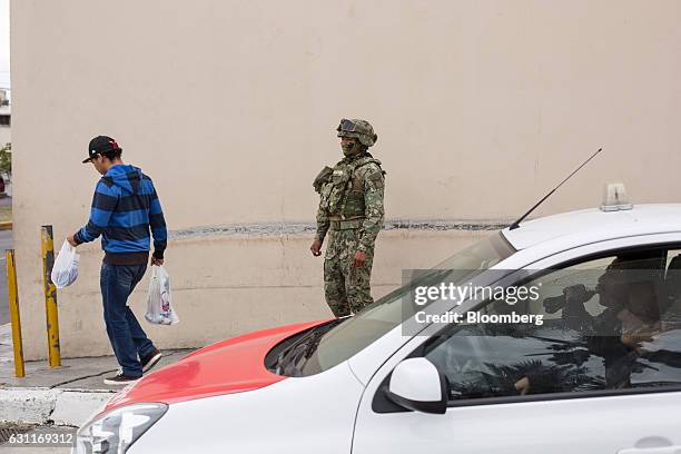 Mexican marine stands guard at a commercial plaza after looting in Veracruz City, Mexico, on Saturday, Jan. 7, 2017. Mexico's National Association Of...