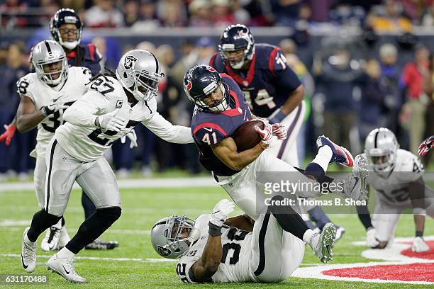 Jonathan Grimes of the Houston Texans is tackled by Khalil Mack of the Oakland Raiders in the AFC Wild Card game at NRG Stadium on January 7, 2017 in...
