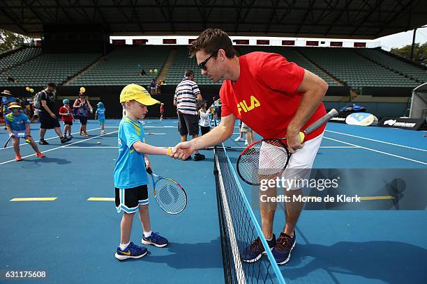 Australian tennis player John Peers shakes hands with a young player after playing tennis with them at Memorial Drive Tennis court during the 2017...