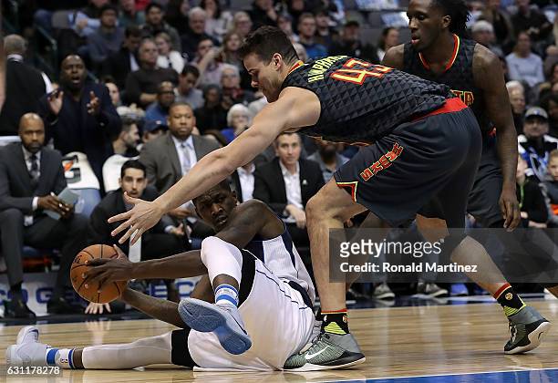 Dorian Finney-Smith of the Dallas Mavericks makes a pass attempt while defended by Kris Humphries of the Atlanta Hawks at American Airlines Center on...