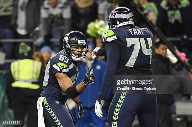 Doug Baldwin of the Seattle Seahawks celebrates with George Fant after scoring a 13-yard touchdown during the fourth quarter against the Detroit...