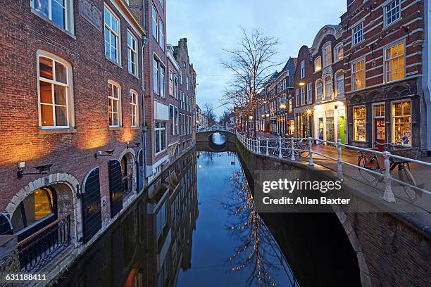 canalside in delft illuminated at dusk - delft stock pictures, royalty-free photos & images