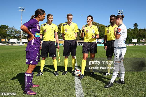 Referee Kate Jacewicz tosses the coin as captains Samantha Kerr of the Glory and Christine Nairn of the Victory look on during the round 11 W-League...