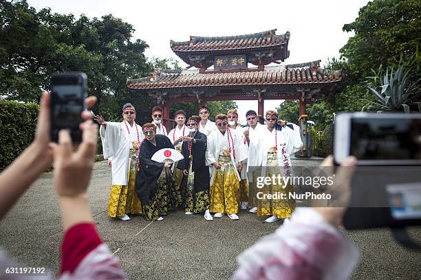 New adults wearing kimonos are seen walking as they enter the Shuri Castle to have their photo taken as remembrance of their friendship during the...