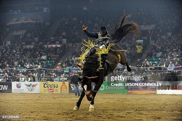 Professional bareback rider Tanner Aus of Pennock, Minnesota, competes during the finals of the "Colorado vs The World Rodeo" at the National Western...