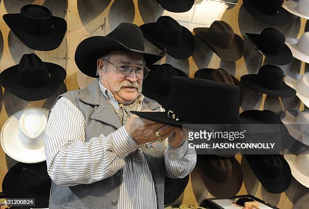 Rick Bishop, owner of Western Traditions and professional cowboy hat shaper, carefully inspects a cowboy hat he has begun bending after steaming it...