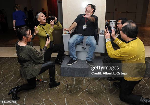 Star Trek cosplayers Michelle Wells, Mark Lum, David Cheng and Bill Arucan pose with the Captain's Chair provided by The Hollywood Sci-Fi Museum at...