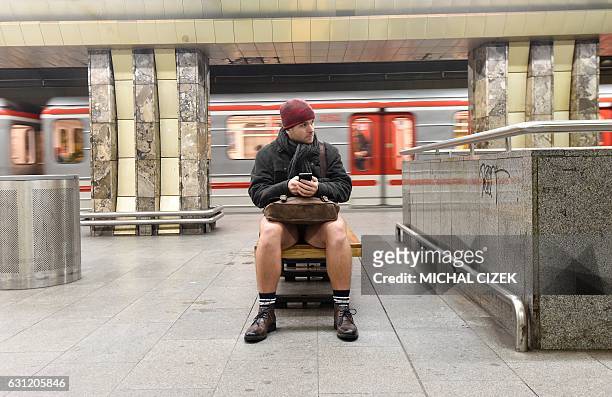 Man without pants sits at a platform during the "No Pants Subway Ride" on January 8, 2017 in Prague. The No Pants Subway Ride is an annual event...