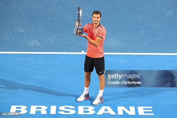 Grigor Dimitrov of Bulgaria holds the Roy Emerson trophy after winning the Men's Final against Kei Nishikori of Japan during day eight of the...