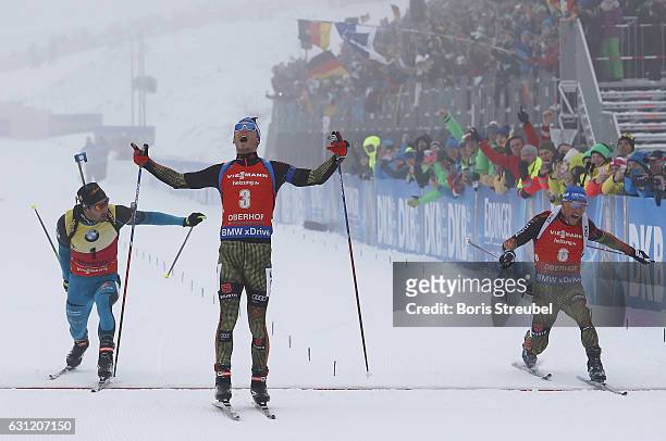 Simon Schempp of Germany crosses the finish line to win the race before second place winner Eric Lesser of Germany and third place winner Martin...