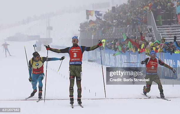 Simon Schempp of Germany crosses the finish line to win the race before second place winner Eric Lesser of Germany and third place winner Martin...