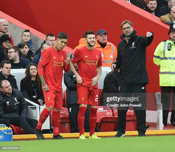 Liverpool manager Jurgen Klopp talks to substitutes Adam Lallana and Roberto Firmino as they come on for Liverpool during the Emirates FA Cup Third...