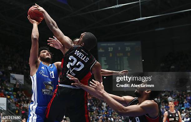 Shavon Shields of Frankfurt is challenged by Cameron Wells and Dwayne Earl Evans of Giessen during the easyCredit BBL match between Fraport Skyliners...