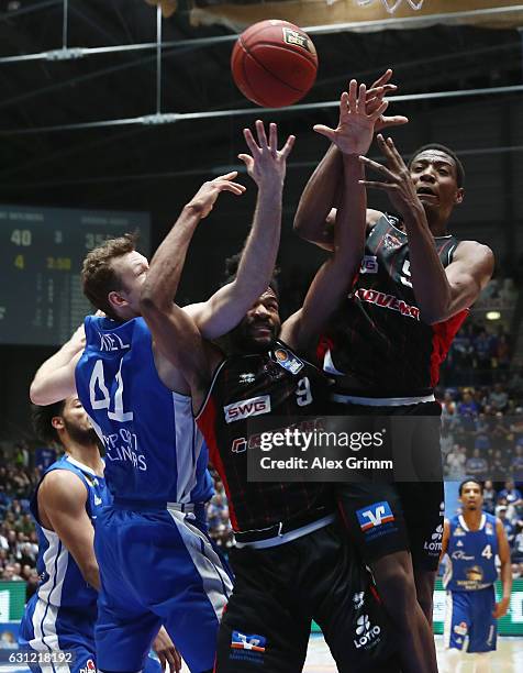 Niklas Kiel of Frankfurt is challenged by Dwayne Earl Evans and Justin Sears of Giessen during the easyCredit BBL match between Fraport Skyliners and...