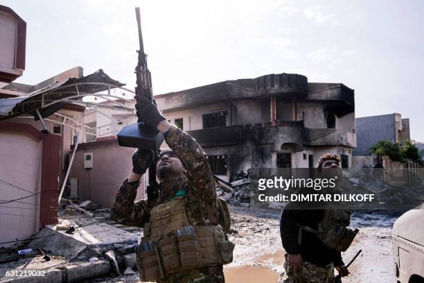 An Iraqi special forces Counter Terrorism Service member shoots at a drone flown by Islamic State group jihadists in Mosul's al-Rifaq neighbourhood...