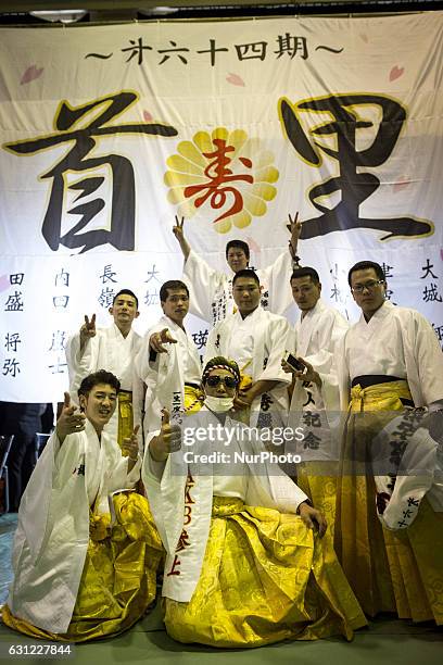 New adults in kimonos takes photos after attending a Coming of Age Day celebration ceremony in Shuri Junior High School in Okinawa, Japan on January...