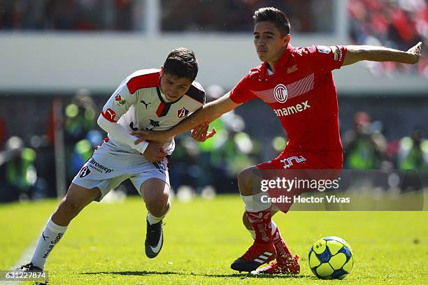 Efrain Velarde of Toluca struggles for the ball with Bryan Garnica of Atlas during the 1st round match between Toluca and Atlas as part of the Torneo...