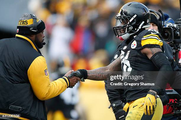 Le'Veon Bell of the Pittsburgh Steelers celebrates with head coach Mike Tomlin after scoring a touchdown during the second quarter against the Miami...