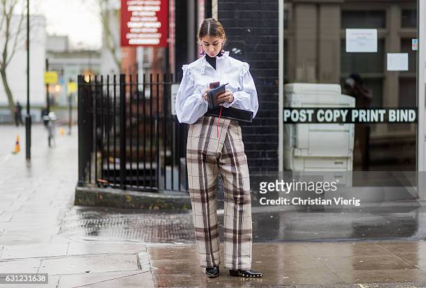 Irina Lakicevic wearing a white blouse, checked pants during London Fashion Week Men's January 2017 collections at JW Anderson on January 8, 2017 in...