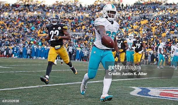 Damien Williams of the Miami Dolphins runs into the end zone for a 4 yard touchdown reception in the fourth quarter during the AFC Wild Card Playoff...