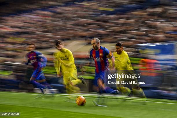 Andres Iniesta of FC Barcelona competes for the ball with Manu Trigueros and Jonathan dos Santos of Villarreal CF during the La Liga match between...