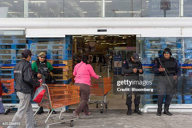 Veracruz state police stand guard outside the entrance of a Chedraui SA store following looting in Veracruz City, Mexico, on Sunday, Jan. 8, 2017....