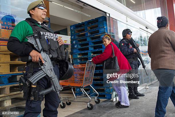 Veracruz state police stand guard outside the entrance of a Chedraui SA store following looting in Veracruz City, Mexico, on Sunday, Jan. 8, 2017....