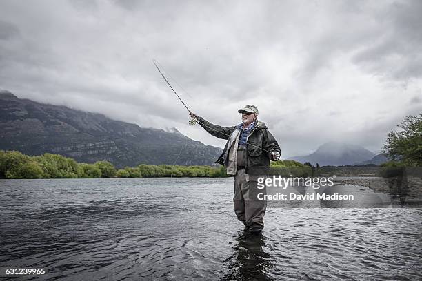 man fly fishing in patagonia - solo un uomo anziano foto e immagini stock