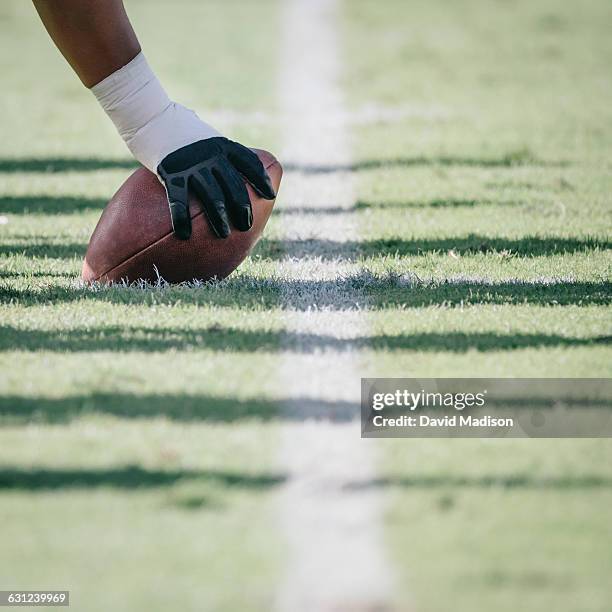 football player with hand on ball - grüner handschuh stock-fotos und bilder