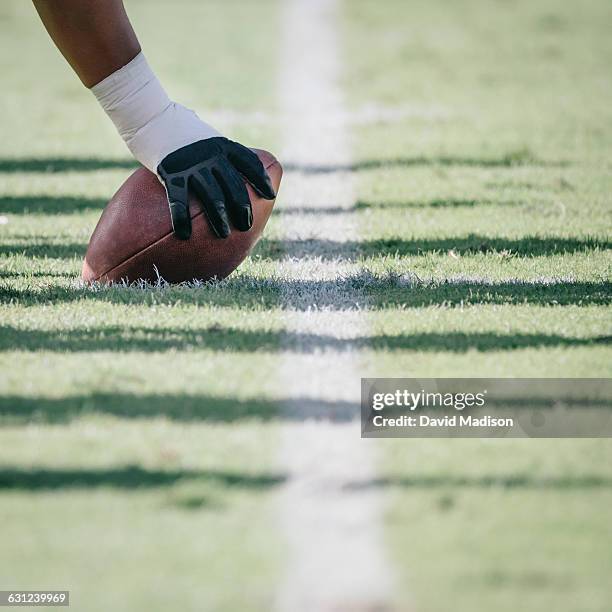 football player with hand on ball - snap fútbol americano fotografías e imágenes de stock