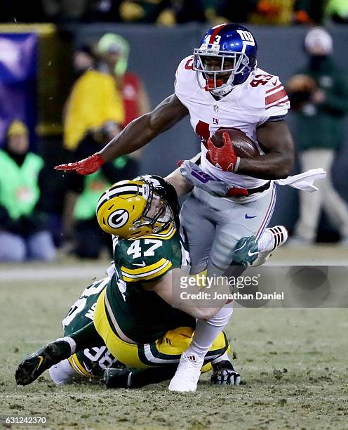 Jake Ryan of the Green Bay Packers tackles Bobby Rainey of the New York Giants in the second quarter during the NFC Wild Card game at Lambeau Field...
