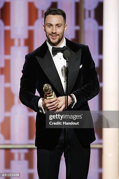 In this handout photo provided by NBCUniversal, Aaron Taylor-Johnson accepts the award for Best Supporting Actor In A Motion Picture for his role in...