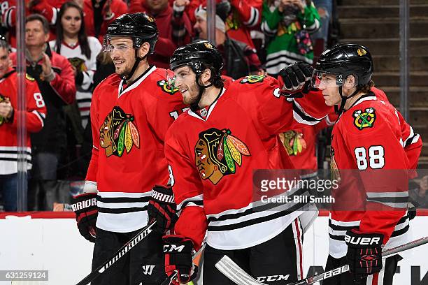 Ryan Hartman of the Chicago Blackhawks celebrates with Artem Anisimov and Patrick Kane after scoring a hat trick against the Nashville Predators in...