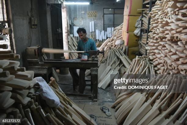 In this photograph taken on December 14 an Indian craftsman works on unfinished cricket bats in a factory in Meerut, some 70kms north-east of New...