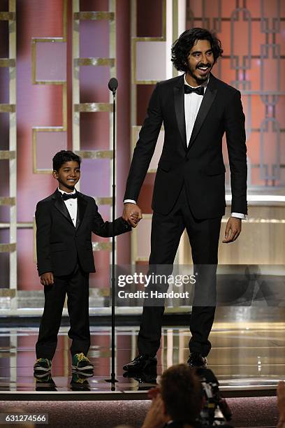 In this handout photo provided by NBCUniversal, presenters Sunny Pawar and Dev Patel onstage during the 74th Annual Golden Globe Awards at The...