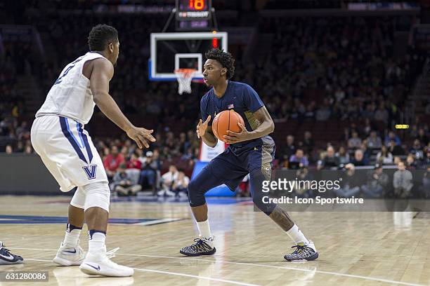Marquette Golden Eagles guard Jajuan Johnson looks for a way around Villanova Wildcats forward Kris Jenkins during the game between the Marquette...