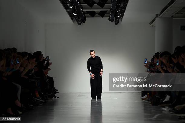 Designer Zio Song salutes the crowd following the SONGZIO show during London Fashion Week Men's January 2017 collections at BFC Show Space on January...