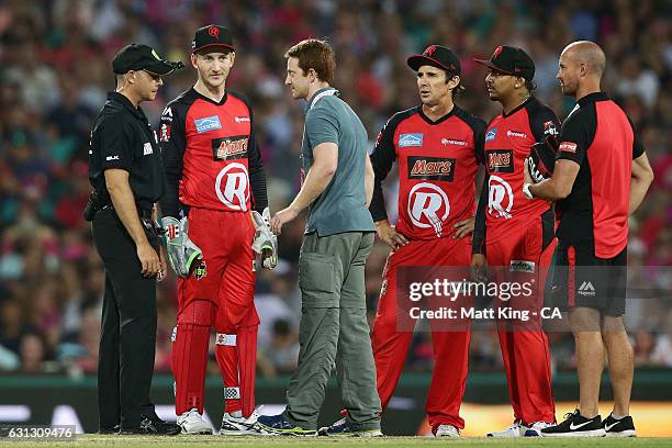 Renegades wicketkeeper Peter Nevill is assessed by medical staff after being hit in the head by the ball during the Big Bash League match between the...