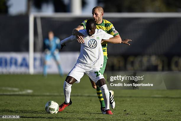 Wolfsburg midfielder Amara Conde holds off Tampa Bay Rowdies forward Keith Savage during the first half of a Florida Cup soccer game between the...