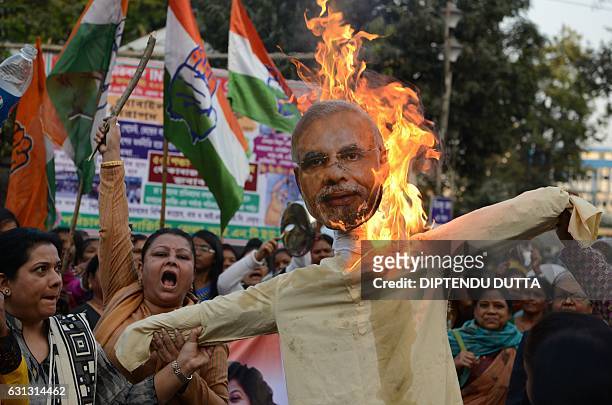 Indian members of the Congress Party burn an effigy of Prime Minister Narendra Modi during a protest against demonetisation in Siliguri on January 9,...