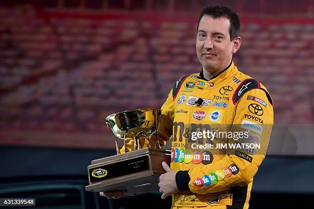 Sprint Cup Series Champion Kyle Busch carries the 2016 NASCAR Manufacturers Trophy at the Toyota press conference during the 2017 North American...