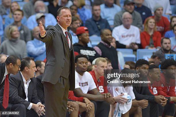 Head coach Mark Gottfried of the North Carolina State Wolfpack directs his team against the North Carolina Tar Heels during the game at the Dean...