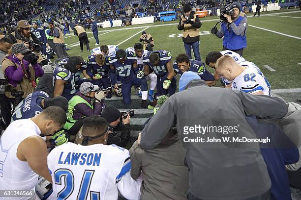 Playoffs: View of players kneeling in prayer on field before Seattle Seahawks vs Detroit Lions game at CenturyLink Field. Seattle, WA 1/7/2017...