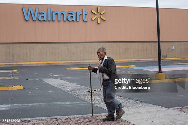Pedestrian passes in front of a closed Wal-Mart de Mexico SAB de CV after being looted during protests against the gasoline price hike in Veracruz,...