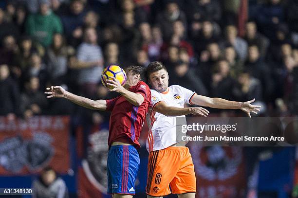 Guilherme Siqueira of Valencia CF duels for the ball with Oriol Riera of CA Osasuna during the La Liga match between CA Osasuna and Valencia CF at...