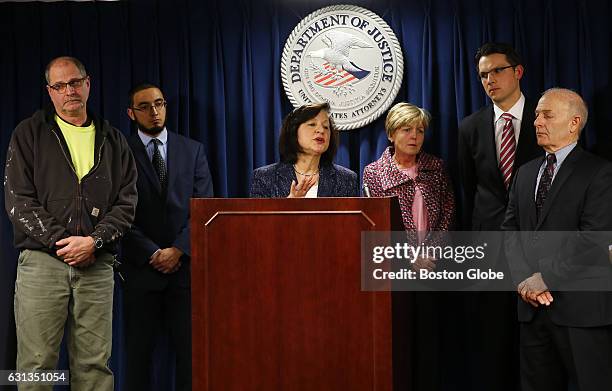 Scott McCloskey, left, the son of Philip McCloskey, who was murdered by Gary Lee Sampson, listens as US District Attorney Camen Ortiz, center, speaks...