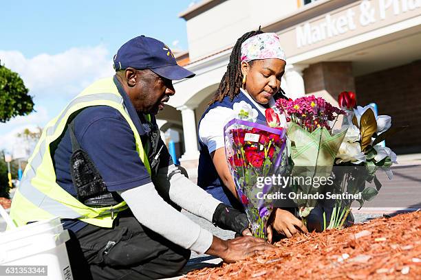 Walmart employees place roses in the mulch outside of the Walmart on Princeton Street on Monday, Jan. 9, 2016 in response to Orlando police Master...