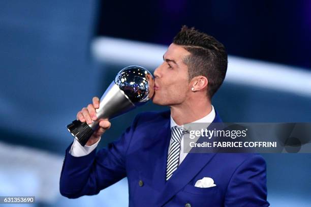 Real Madrid and Portugal's forward Cristiano Ronaldo kisses his trophy after winning the The Best FIFA Men's Player of 2016 Award next to FIFA...