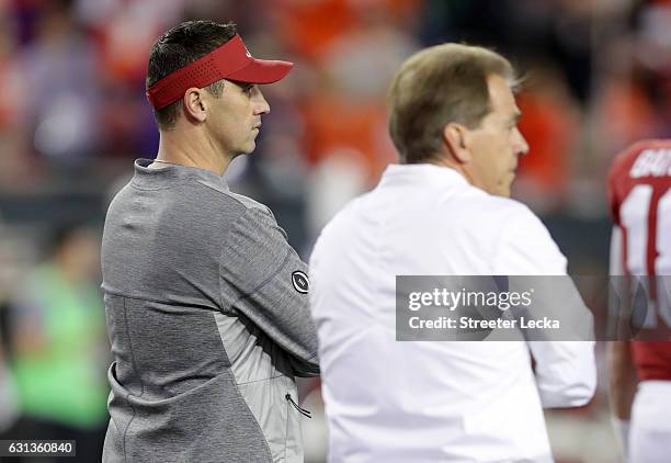 Offensive coordinator Steve Sarkisian of the Alabama Crimson Tide stands alongside head coach Nick Saban before taking on the Clemson Tigers in the...